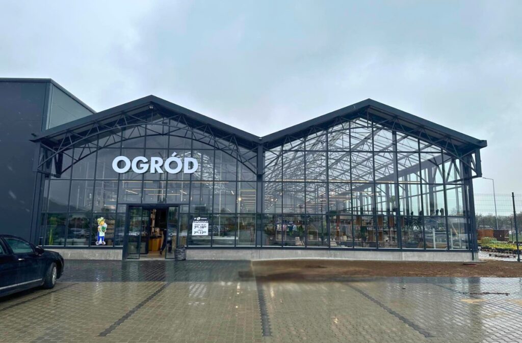 Wejście do działu ogrodniczego PSB Mrówka w Strzegomiu – przeszklona konstrukcja szklarniowa po zakończeniu budowy.