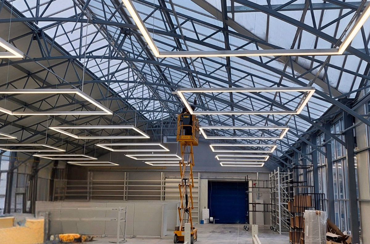 Pracownik budowlany podczas montażu instalacji w centrum ogrodniczym.