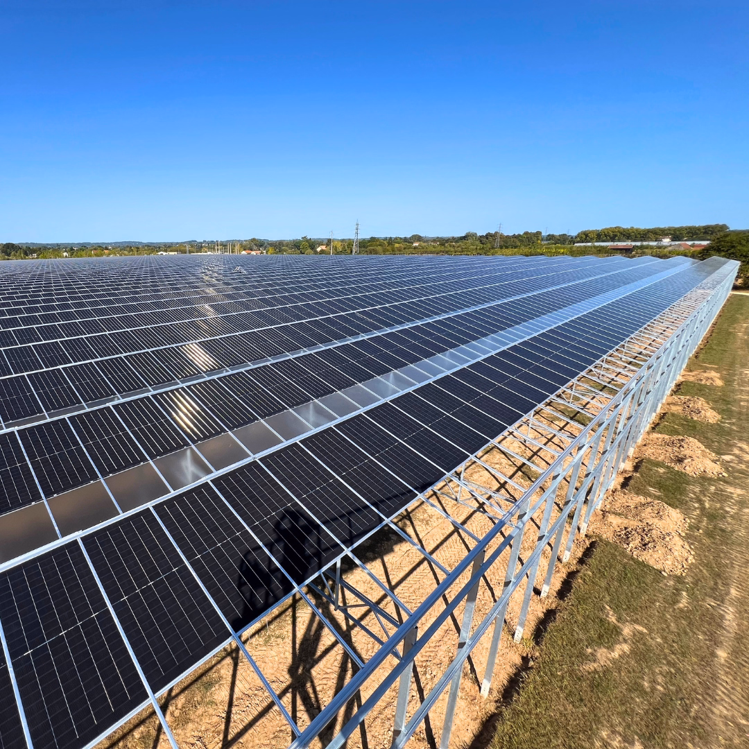 Widok na dach szklarni wykończony panelami fotowoltaicznymi.
