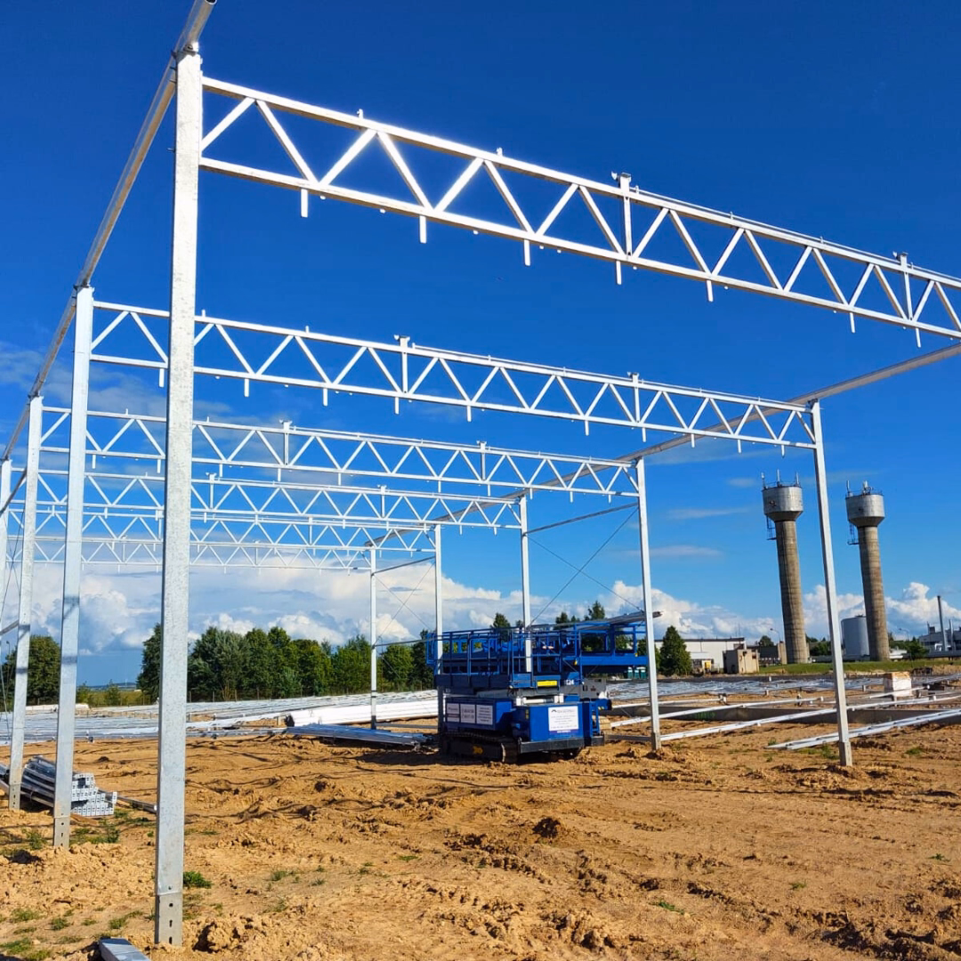 Pierwsze stawiane elementy konstrukcji szklarni na wczesnym etapie montażu.