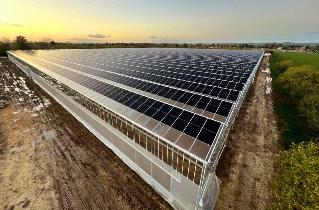 Zamontowane panele fotowoltaiczne na dachu szklarni, widok z góry na gotowy system PV.