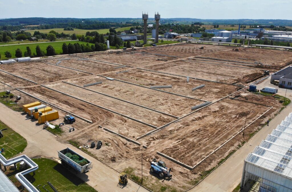 Teren przygotowany pod budowę szklarni z wyznaczonymi sekcjami i liniami fundamentów.