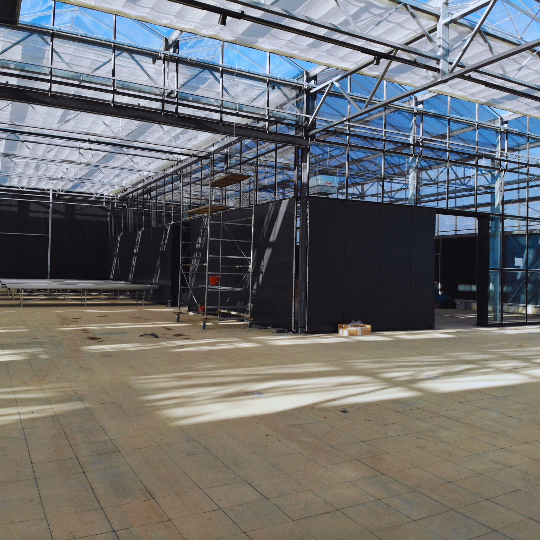 wnętrze centrum ogrodniczego Garden Paradise: stalowa konstrukcja, przeszklony dach z osłonami, posadzka z płytek oraz zamontowana zabudowa