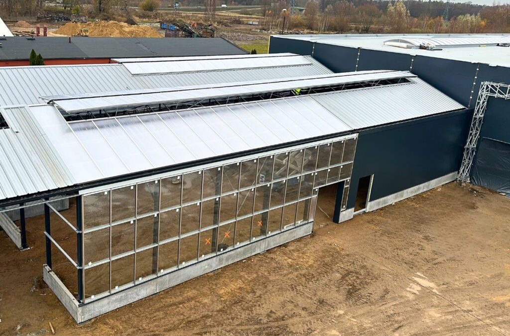 Montaż ścian z płyt warstowych i szkła w części ogrodniczej połączonej z halą marketu PSB Mrówka.