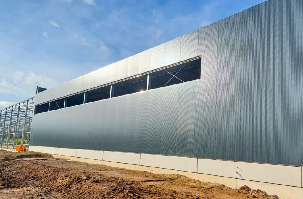 Prace wykończeniowe przy elewacji wolnostojącego centrum ogrodniczego.