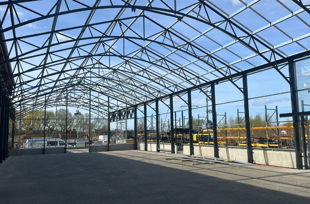 Widok na montaż konstrukcji szklarniowej działu ogrodowego.