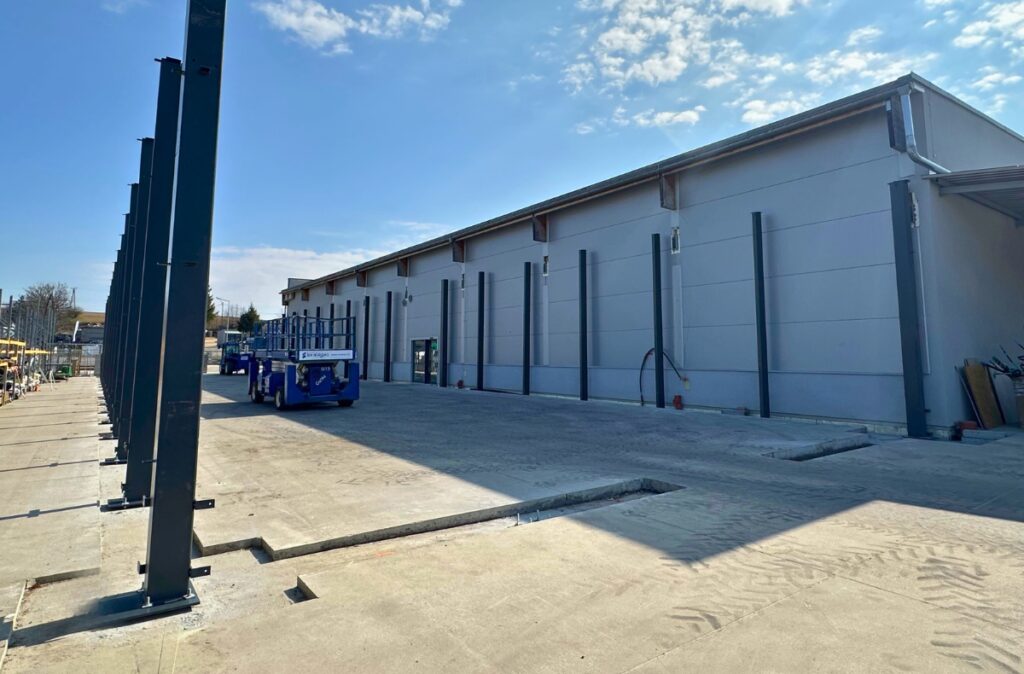 Plac budowy przy markecie budowlanym z montowaną konstrukcją stalową działu ogrodowego.