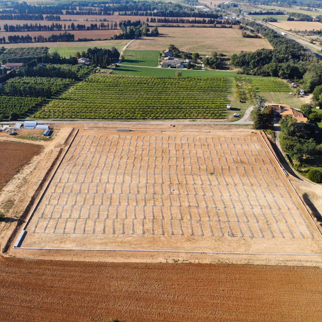 Teren inwestycji wraz z elementami konstrukcji szklarni fotowoltaicznej przygotowane do montażu.
