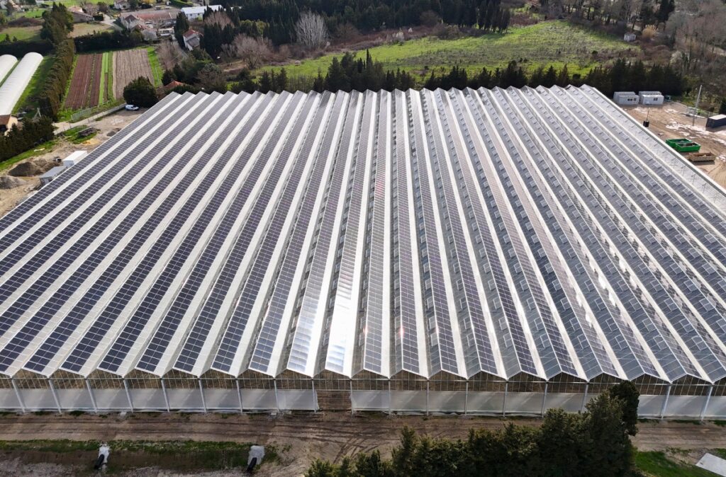 Widok z lotu ptaka na szklarnię fotowoltaiczną z w pełni zabudowanym dachem.