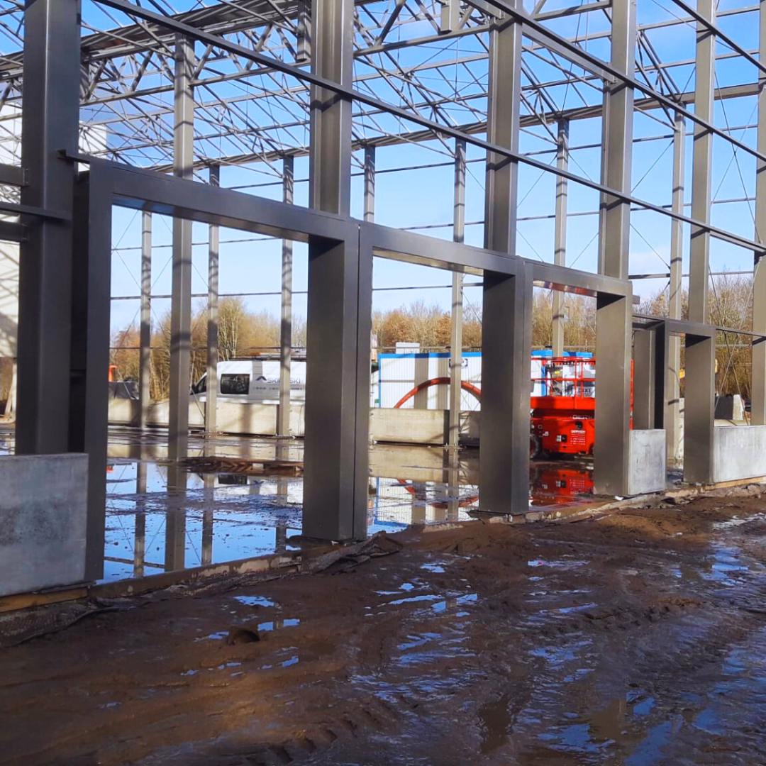 Montaż stalowej konstrukcji centrum ogrodniczego Theux – realizacja prowadzona w trudnych warunkach terenowych.