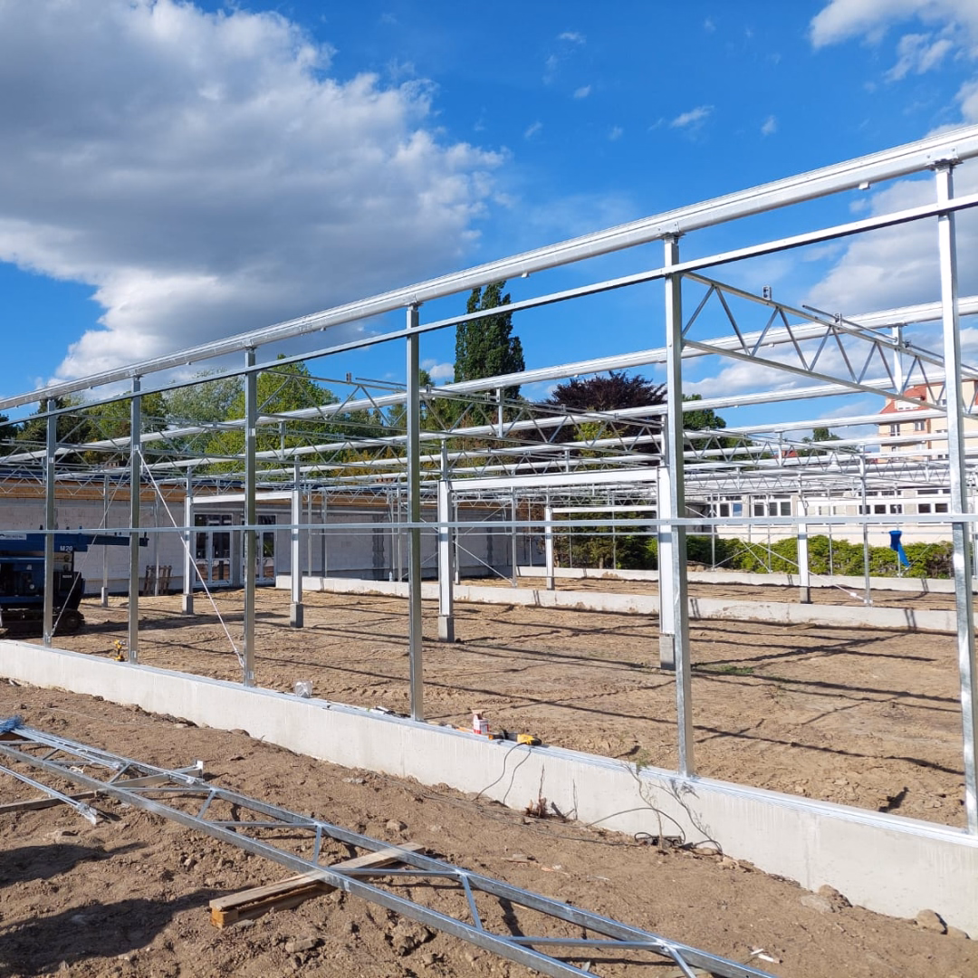 Montaż stalowej konstrukcji szklarni doświadczalnej na terenie szkoły.