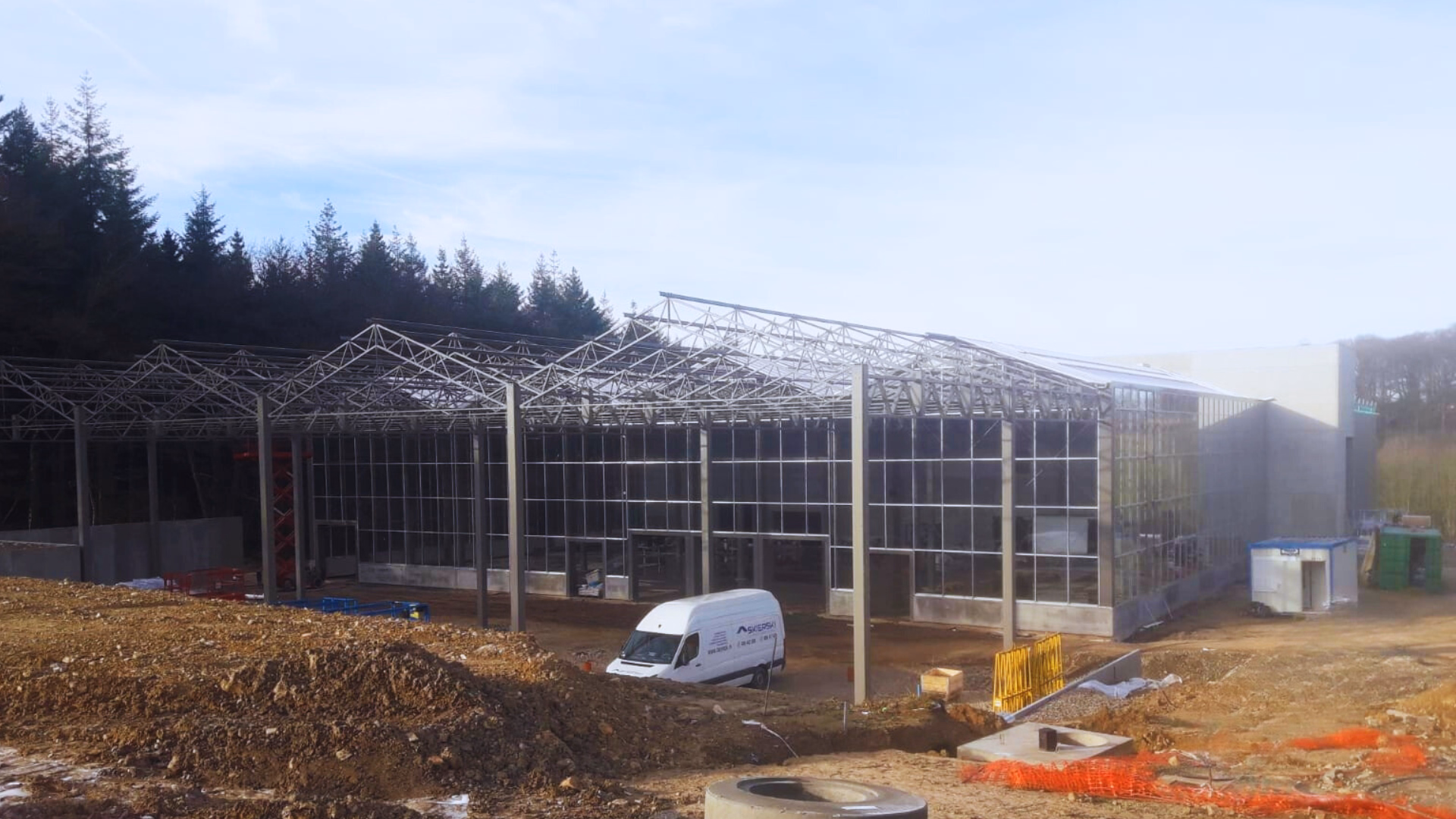 Budowa wolnostojącego centrum ogrodniczego w Theux w Belgii – montaż stalowej konstrukcji szklarniowej połączonej z halą handlową.