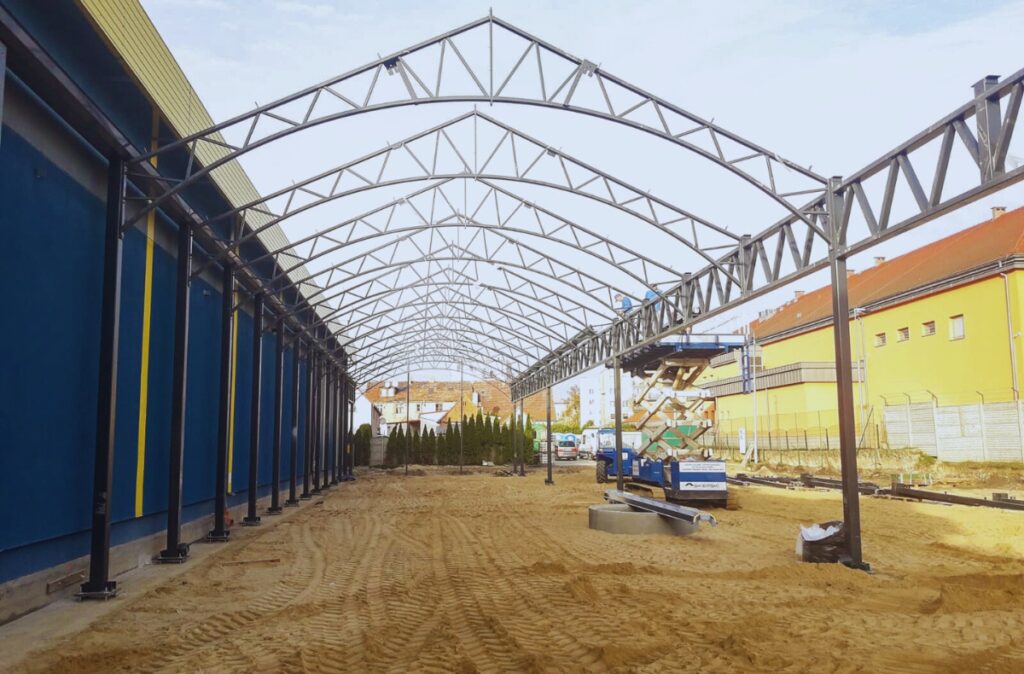 Budowa centrum ogrodniczego Mrówka Międzyrzecz – montaż stalowej konstrukcji hali ogrodowej w trakcie realizacji.