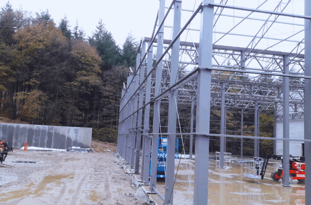 Budowa szklarni handlowej w Theux – etap wznoszenia konstrukcji dachowej i elementów nośnych.