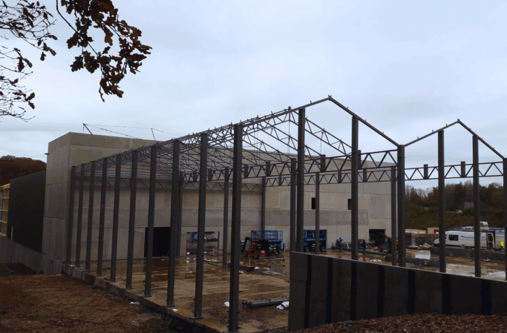 Połączenie nowej szklarni z istniejącą halą prefabrykowaną w centrum ogrodniczym Theux.