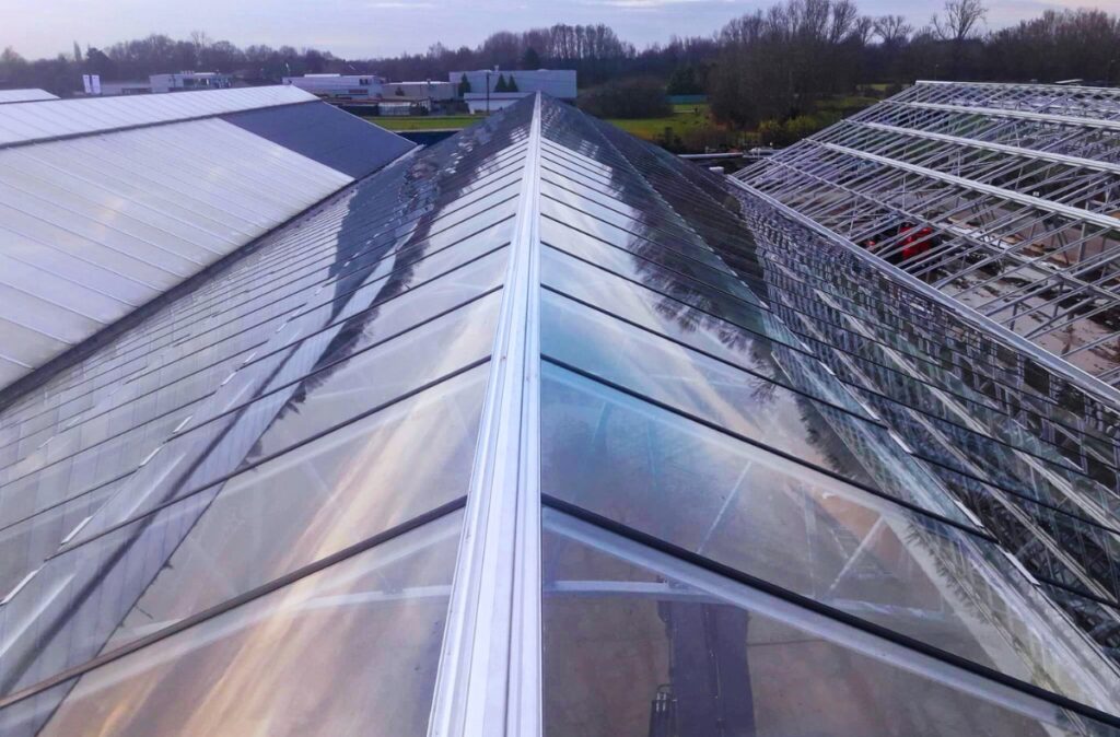 Szklany dach szklarni sprzedażowej z kalenicą i systemem świetlików dachowych w centrum ogrodniczym Thiels Garden Center.
