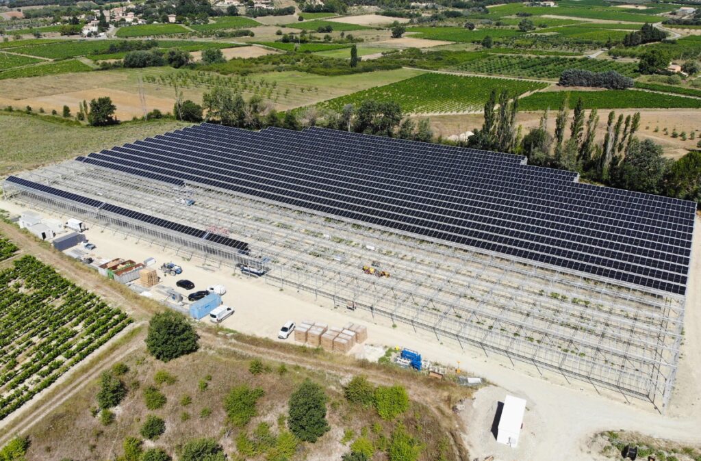 Instalacja paneli fotowoltaicznych na konstrukcji szklarni.