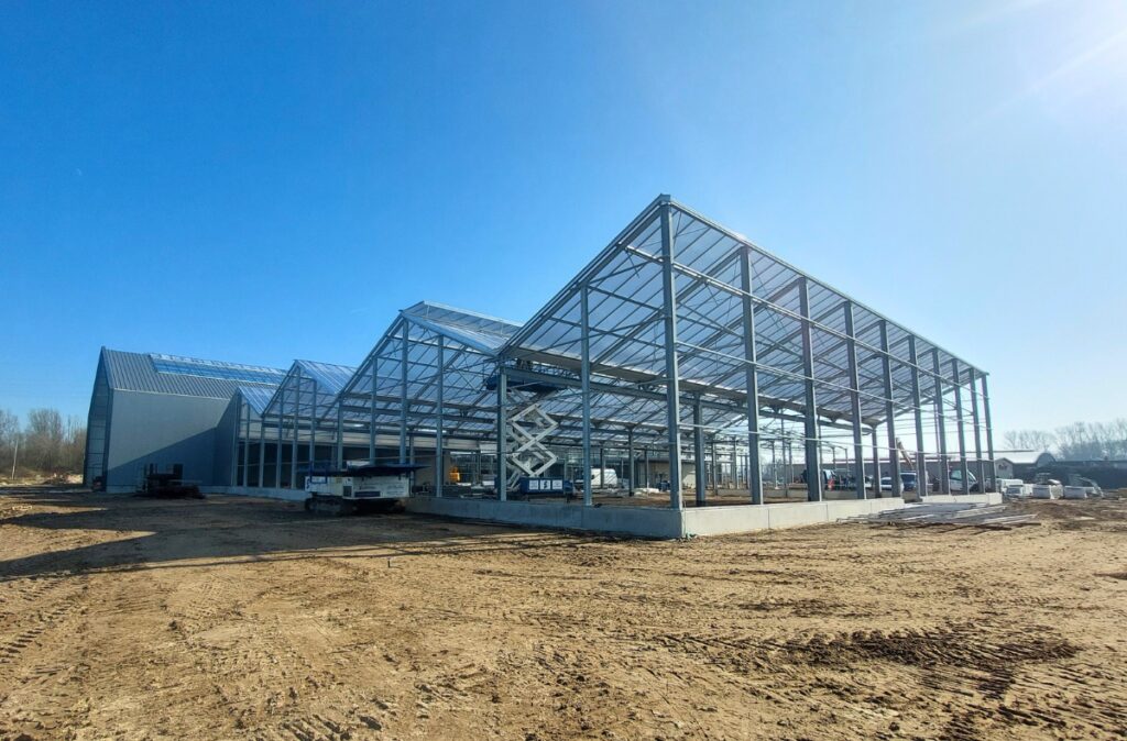 Wznoszenie konstrukcji na bazie szklarni połączonej z częścią kubaturową obiektu.