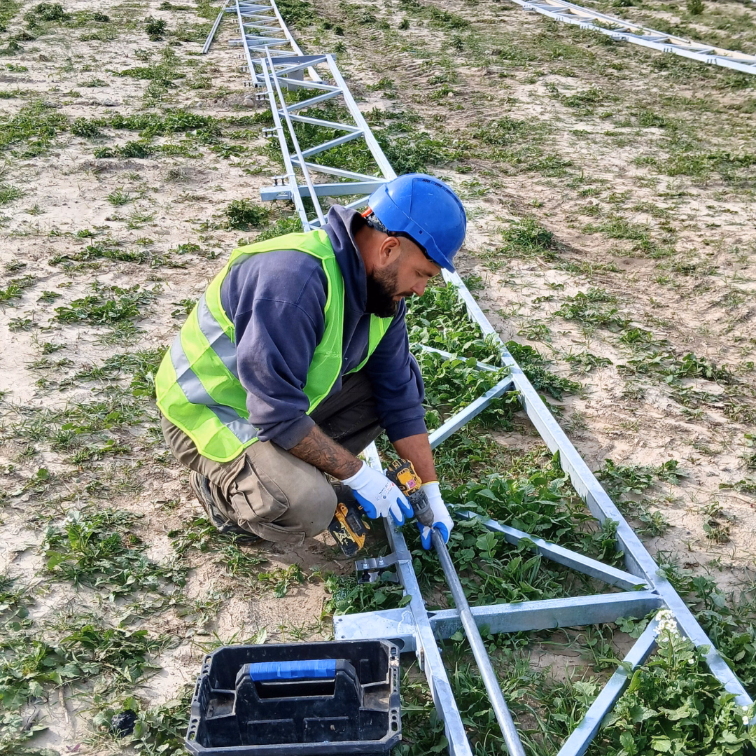 Technik skręcający elementy konstrukcji szklarni fotowoltaicznej.