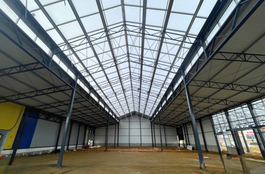 Wnętrze hali ogrodniczej z naturalnym doświetleniem dachu.