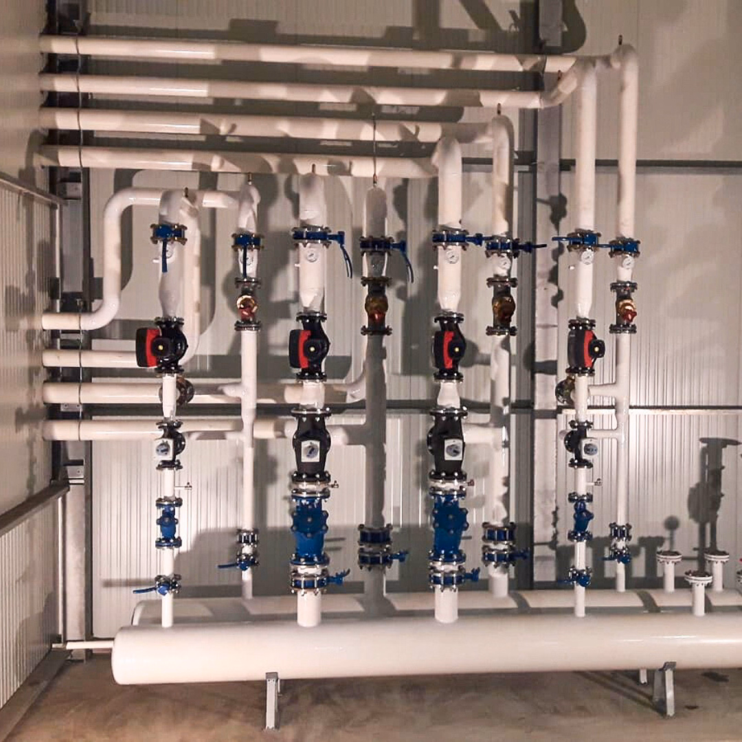 Układ centralnego ogrzewania w szklarni - rurociągi, zawory i pompy obiegowe.