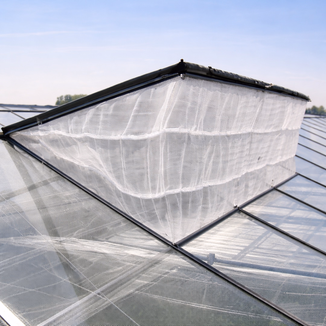 Siatka na owady zamontowana w wietrzniku dachowym szklarni.