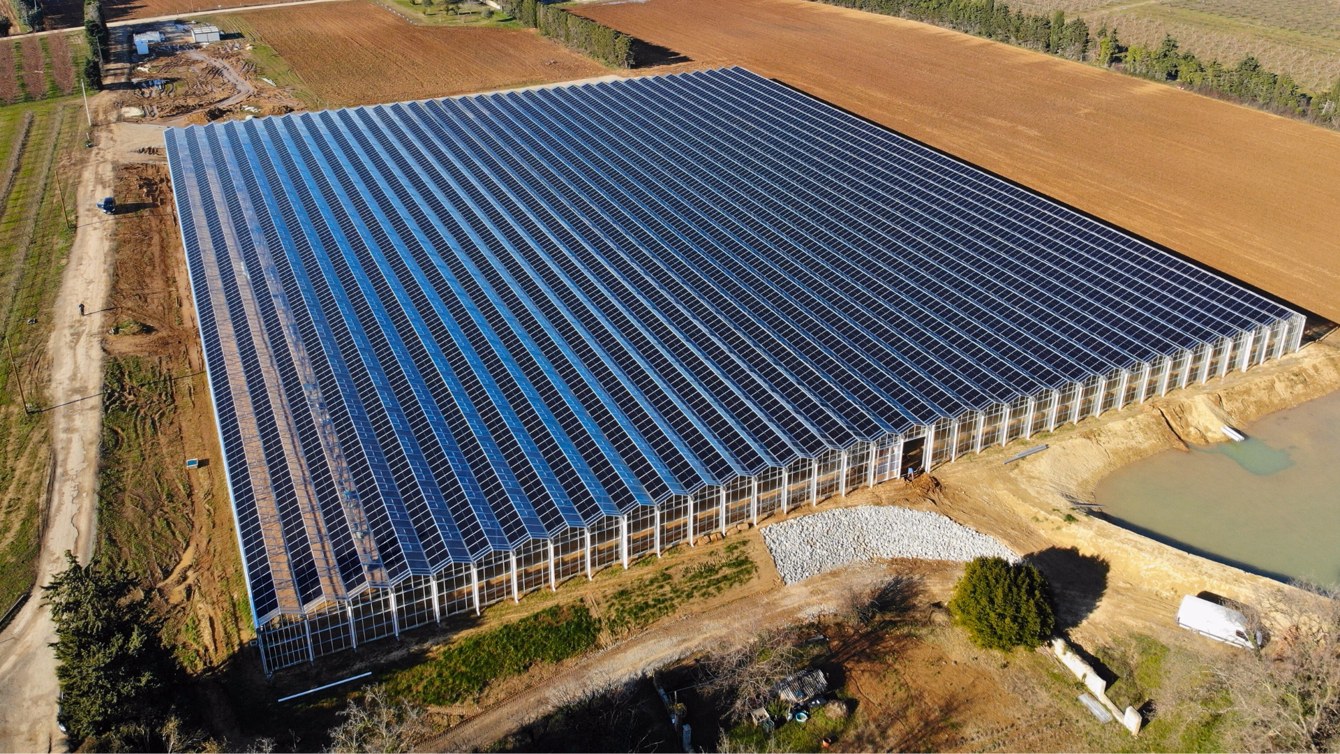 Szklarnia fotowoltaiczna z panelami PV na dachu - widok z lotu ptaka.