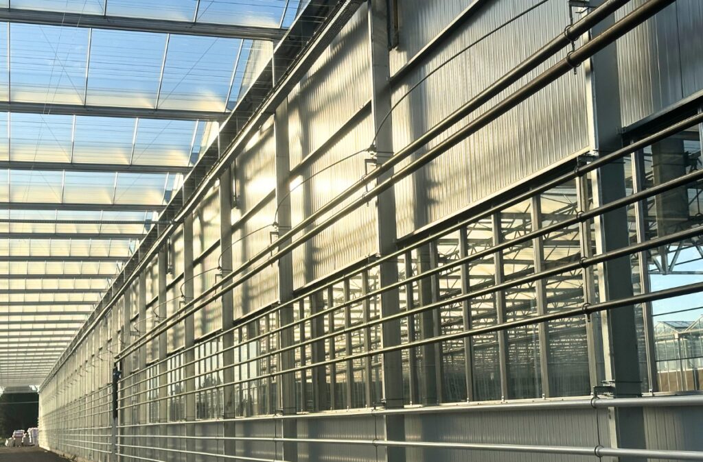 Połączenie konstrukcji szklarniowej z elewacją z paneli warstwowych sandwich.