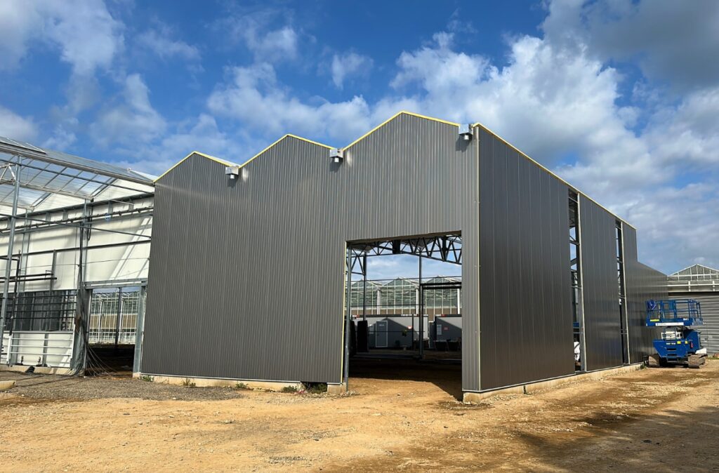 Zewnętrzna ściana hali sandwich zintegrowanej z obiektem szklarniowym.